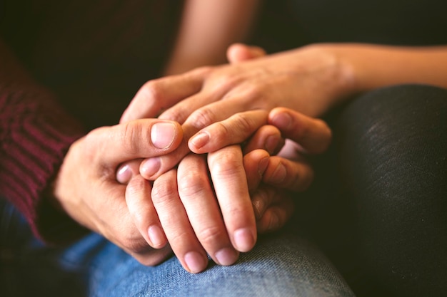 Sweet couple holding hands close up