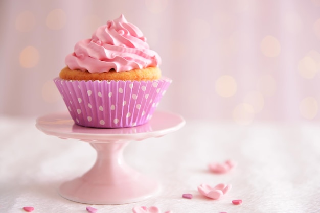 Sweet cupcake on table on light background