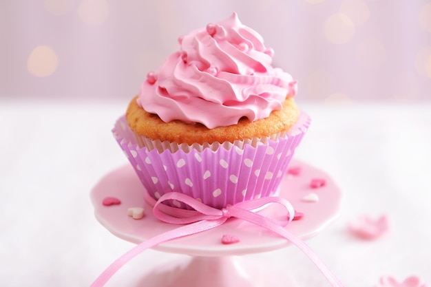 Sweet cupcake on table on light background