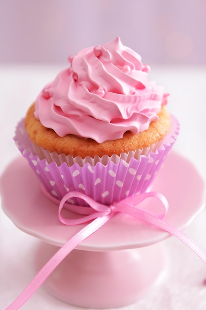 Sweet cupcake on table on light background