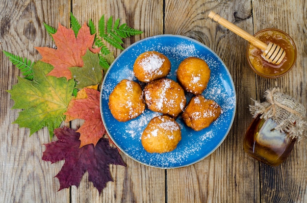 Sweet curd donuts buns with powdered sugar on wooden table.