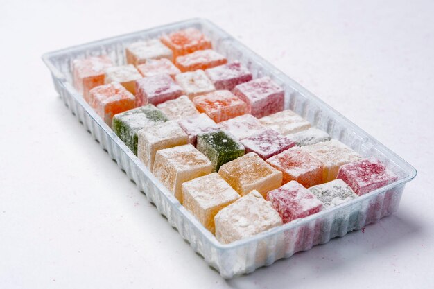 Sweet delicious colored lukum Turkish delight with powdered sugar on a white background