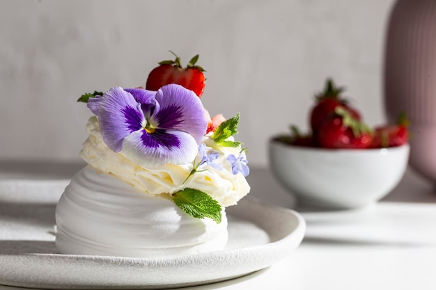 Sweet dessert Anna Pavlova decorated with flowers