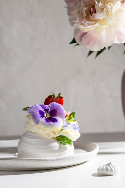 Sweet dessert Anna Pavlova decorated with flowers