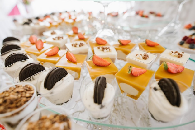 Sweet dessert cakes and cupcakes and jellys on the candy bar at the celebration