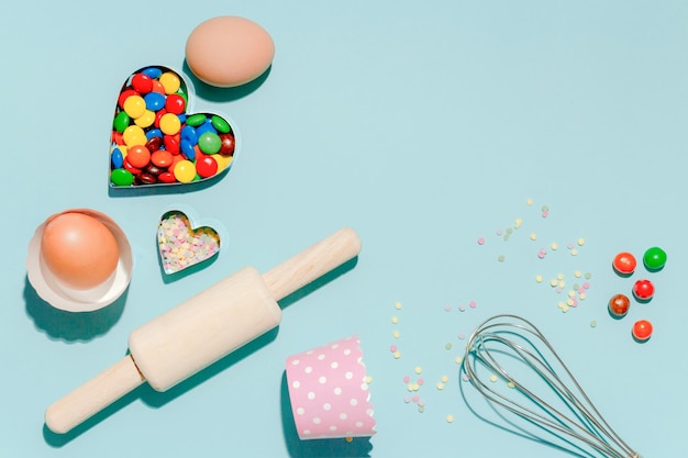 Sweet dessert concept Various confectionery tools and candy on light blue background