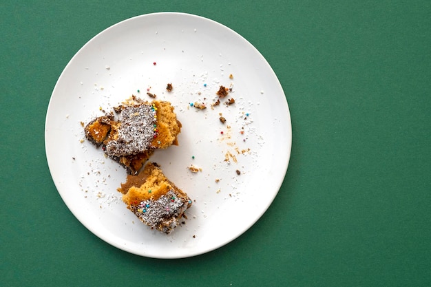 Sweet dessert food leftover on a white ceramic plate with green tablecloth