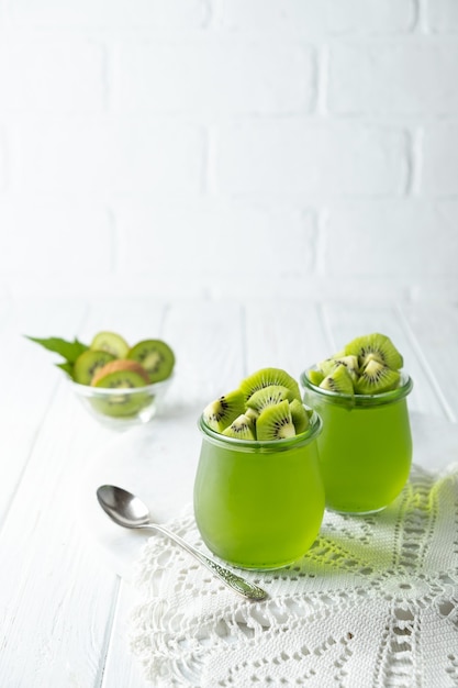 Budino di gelatina dolce dessert con kiwi in vaso di vetro su sfondo bianco