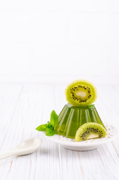 Sweet dessert jelly pudding with kiwi on white plate