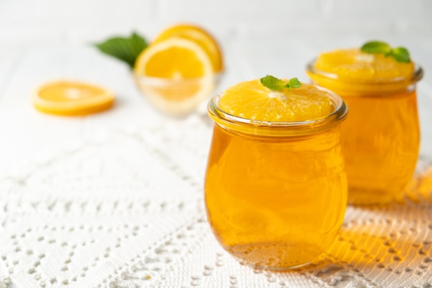 Sweet dessert jelly pudding with orange citrus in glass jar on white background