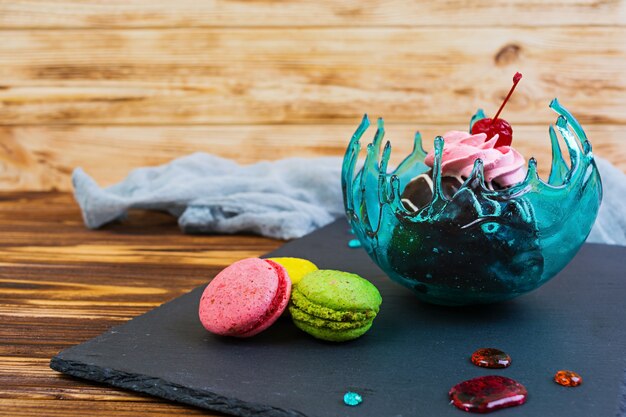 Sweet dessert and macaron in caramel bowl on wooden 