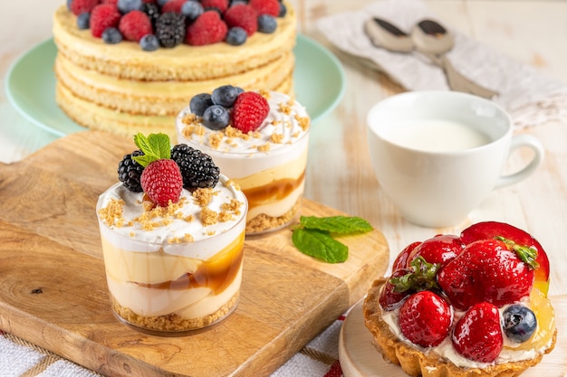 Sweet desserts with fresh berries on wooden