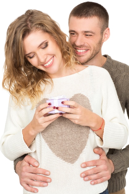 Sweet details. Vertical studio shot of a loving happy couple posing isolated on white woman holding a little present