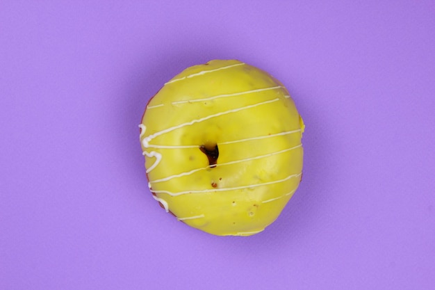 Photo sweet donut glazed on a purple background closeup of a sweet dessert view from above