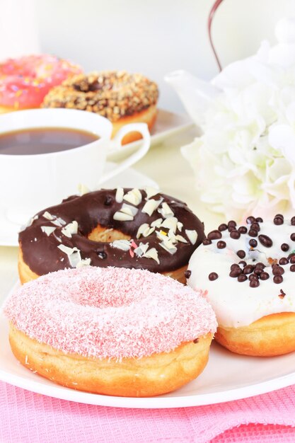 Foto donut dolci con una tazza di tè sul tavolo su uno sfondo chiaro