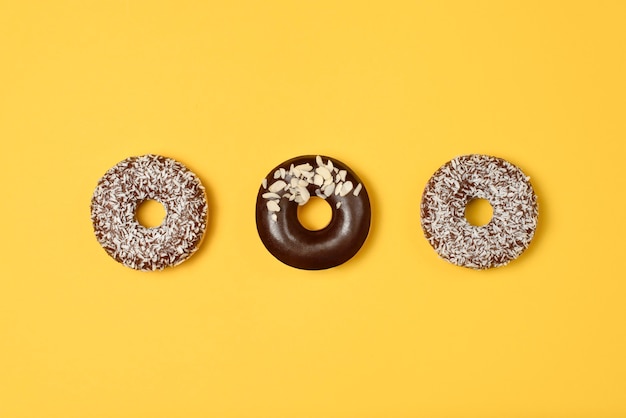 Sweet donuts on yellow background. Top view. Flat lay. Food concept.