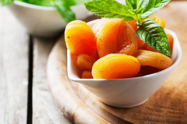 Sweet dried apricots and mint on the wooden table