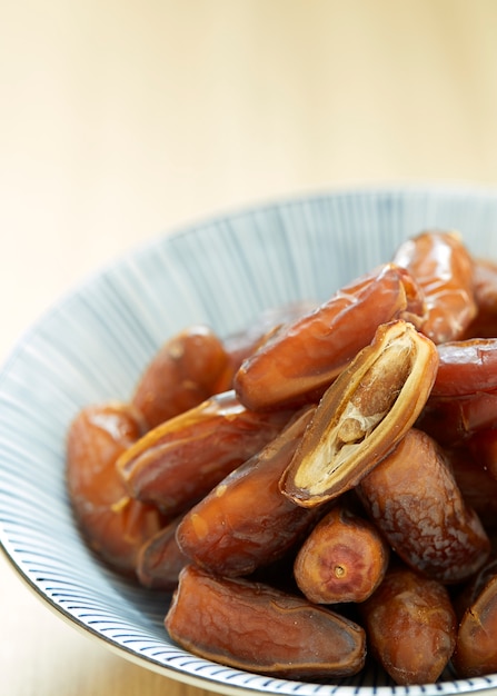 Sweet dried dates fruit in a bowl and on the table