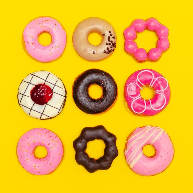 Sweet Fashion Donuts set on a yellow background. Flat lay fast food minimal art