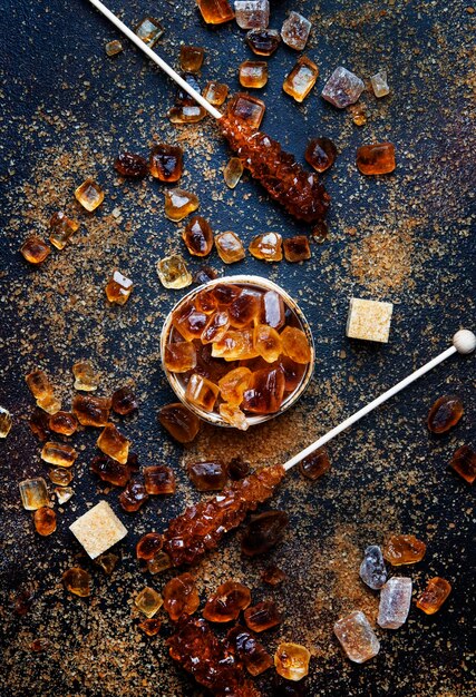 Sweet food background assorted white and brown sugar on a dark background top view