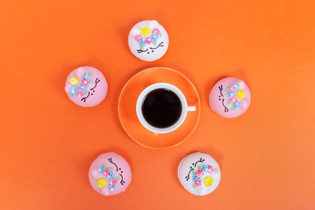 Sweet food and a cup of coffee on an orange background Food and drinks