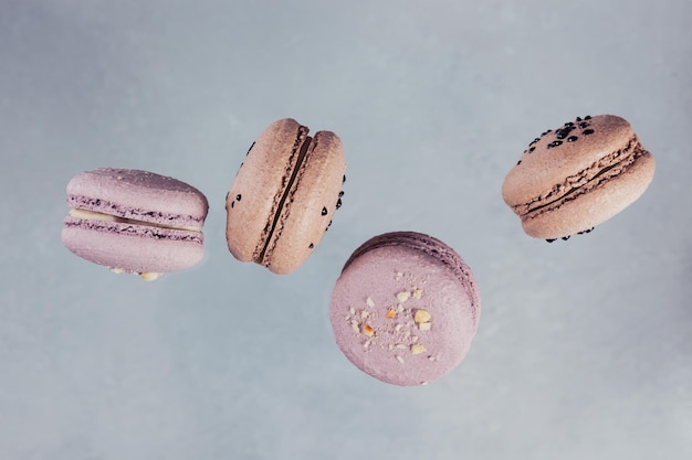 Sweet french macarons falling in motion on grey background