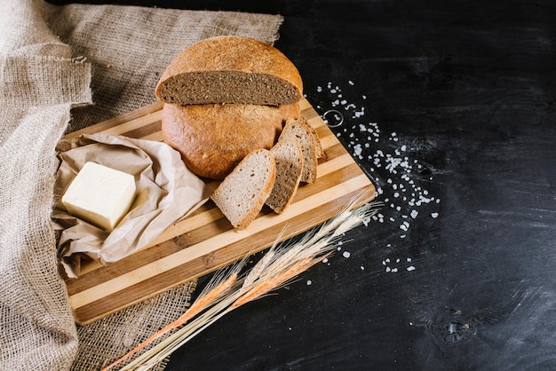 Sweet fresh bread with ingredients on black wooden background