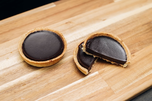 Sweet fresh dark chocolate tart on the wooden table