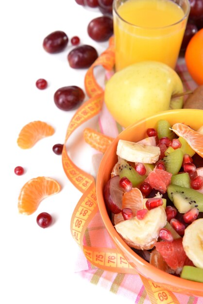 Sweet fresh fruits in bowl on table closeup