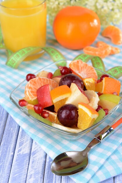 Sweet fresh fruits in bowl on table closeup