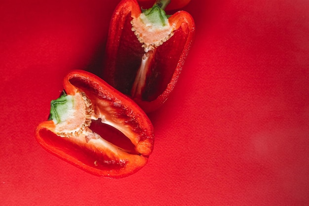 사진 빨간색 배경에 달콤한 신선한 고추 메뉴 적절한 영양 신선한 야채를 위해 반으로 자른 사진