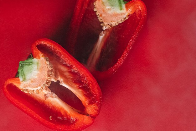 SWEET fresh RED PEPPER ON A RED BACKGROUND cut in half photo for the menu proper nutrition fresh vegetables