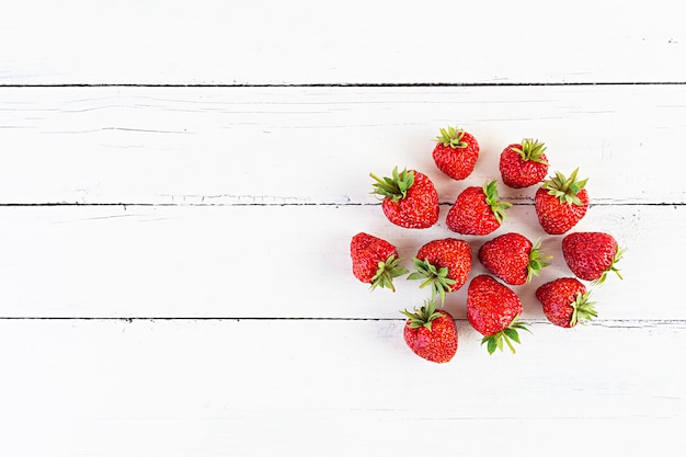 Sweet fresh ripe strawberry isolated on white wooden background.