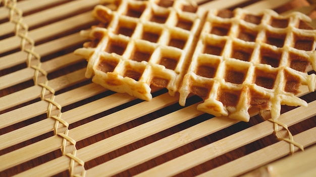 Sweet fresh Viennese waffles on rustic wooden background. Selective focus, horizontal.