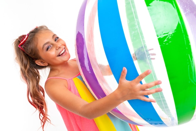 Photo sweet girl about to swim in the sea with a rubber ring and a mattress on an isolated white background.