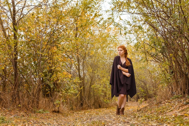 Sweet girl in the autumn forest, loneliness and melancholy