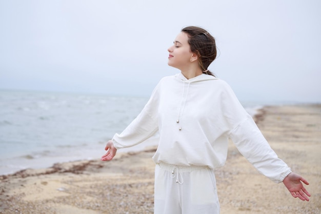 Sweet girl taking deep breathe at the beach in the morning High quality photo