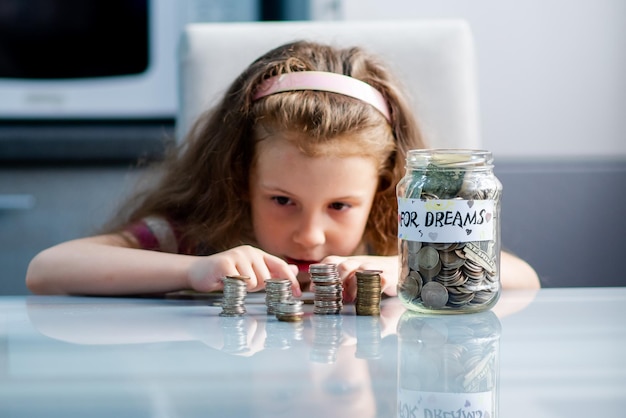 A sweet girl with full piggy bank of coins The money Savings Childhood