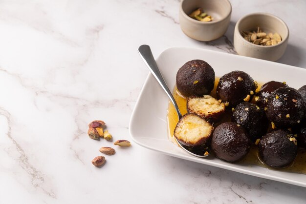 Sweet Gulab Jamun on whiet plate on marble background