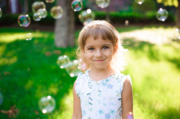 Sweet, happy, smiling five year old girl laying on a grass