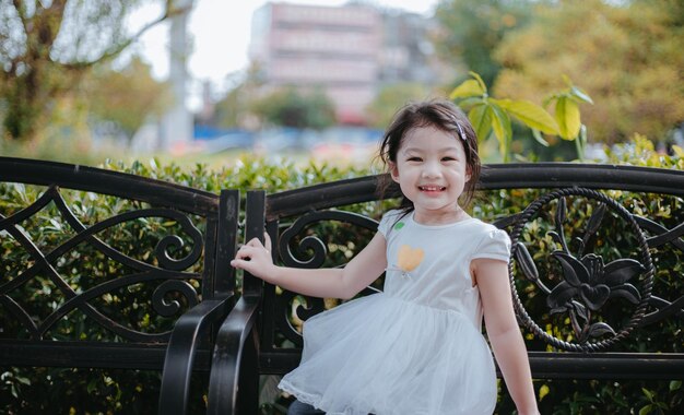 屋外の公園で遊ぶ甘い幸せな笑顔の 3 歳の女の子