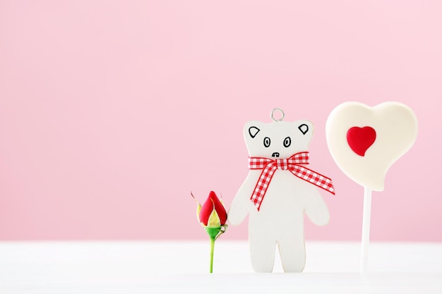 Sweet heart with toy bear on table on pink background