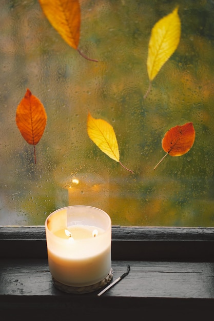 달콤한 홈 나무 창에 집에서 정물 세부 사항 스웨터 양초 뜨거운 차와 가을 장식 가을 가정 장식 아늑한 가을 분위기 추수 감사절 할로윈 아늑한 가을 또는 겨울 개념