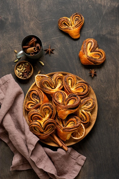 Sweet homemade cinnamon rolls in the shape of a heart on an old retro style New Year mood Traditional Swedish cinnabons Selective focus