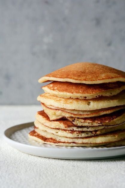 Sweet Homemade Stack of Pancakes with  honey for Breakfast  on a gray background. Sweet beautiful breakfast. Brunch. Family Breakfast. Concept for cafes, restaurants, fast food outlets, bars