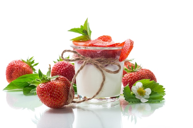 Sweet homemade yogurt with strawberry jam and fresh strawberries in a glass cup