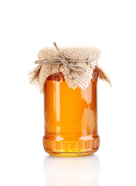 Photo sweet honey in jar isolated on white