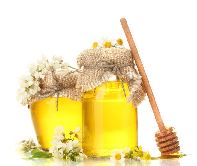 Sweet honey in jars and acacia flowers isolated on white