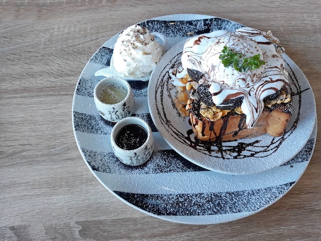 Фото Сладкий медовый тост в тарелке, украшенной совок мороженого сверху