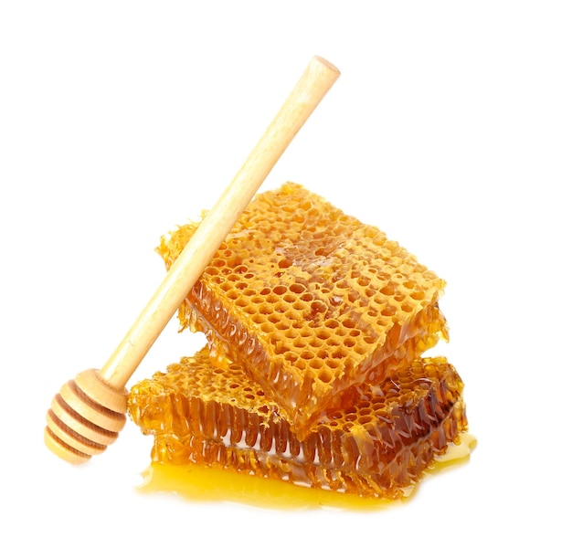 Sweet honeycomb and wooden drizzler isolated on white